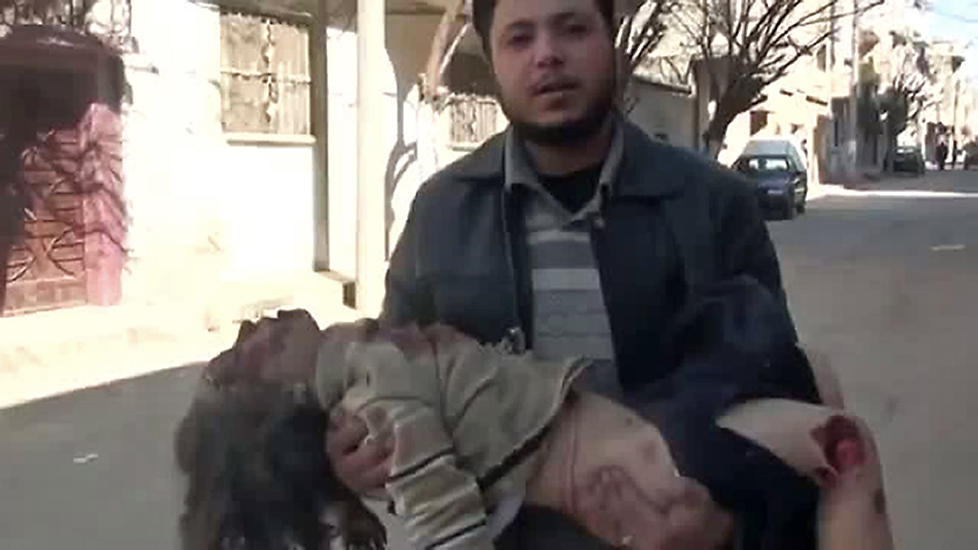 STERKE SCENER: En mann b�rer en liten jente som skal ha blitt drept da sikkerhetsstyrkene fyrte l�s mot folkemengdene i byen Homs. Bildet er hentet fra en video p� Youtube, og er ikke verifisert av andre kilder.  Foto: AFP PHOTO/YOUTUBE