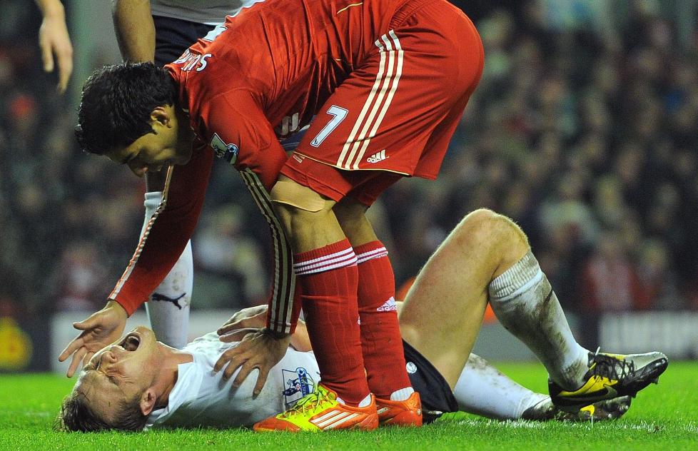 UNNSKYLDTE SEG: Luis Suarez var kjapt nede hos Scott Parker for � beklage seg etter � ha sparket Tottenham-spilleren i magen. Foto: AFP PHOTO/ANDREW YATES
