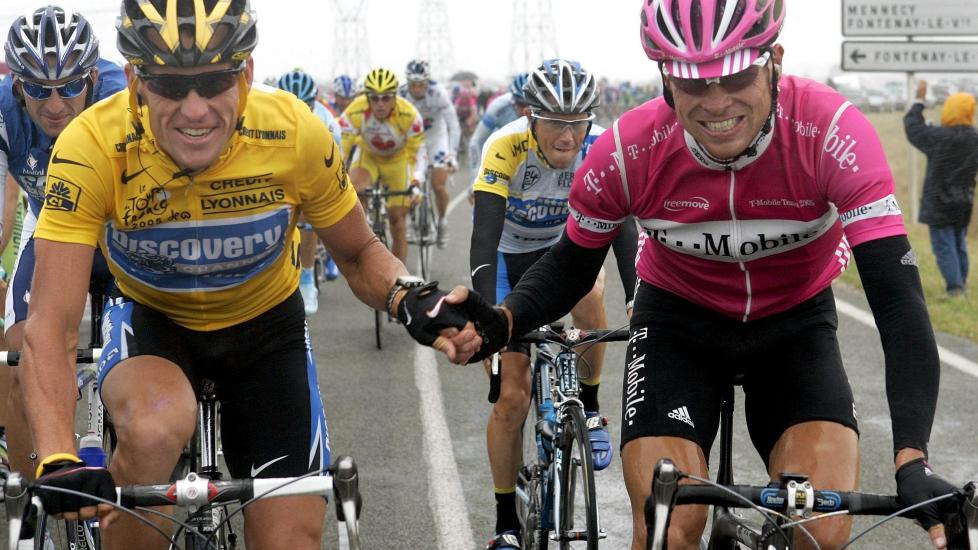 MISTER TREDJEPLASS: Jan Ullrich holder lanke med Lance Armstrong ved starten av siste etappe i Tour de France 2005. Ullrich ble i dag fratatt tredjeplassen i sammendraget bak Armstrong og Ivan Basso. Foto: Gero Breloer, EPA/Scanpix
