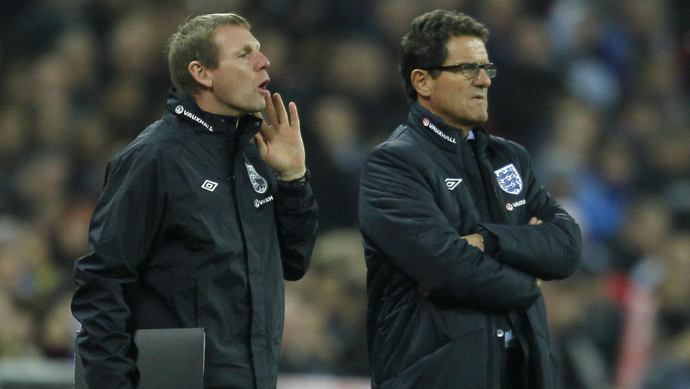 MIDLERTIDIG SJEF: Stuart Pearce (t.v.) leder England mot Nederland i slutten av februar. Den neste kampen for England er mot Norge p� Ullevaal 26. mai. Innen den tid regner FA med � ha p� plass treneren som skal erstatte Fabio Capello (t.h.) p� fast basis. Foto: Ian Kington, AFP/Scanpix