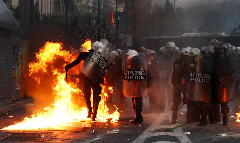  KASTET BENSINBOMBER: Demonstranter kastet bensinbomber mot politiet utenfor det greske parlamentet i kveld. 100 000 demonstranter skal ha tatt til gatene. Foto: AFP PHOTO / ANGELOS TZORTZINIS / SCANPIX