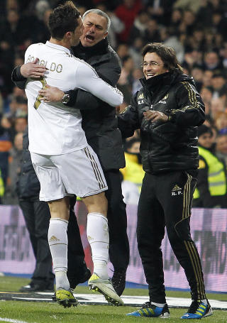 HOPPENDE GLADE: Portugiserne Cristiano Ronaldo og Jose Mourinho hopper i armene p� hverandre etter ett av Ronaldos tre m�l i kveld. N� har Real Madrid ti poengs forsprang p� Barcelona. Foto: Andres Kudacki, AP/Scanpix