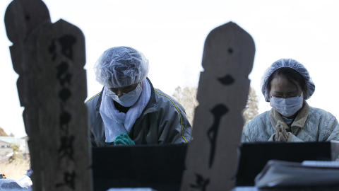 BER: Minoo Fukuo og hans kone Kinuko ber ved farens gravstein. Foto: Kim Kyung-Hoon/Reuters/Scanpix