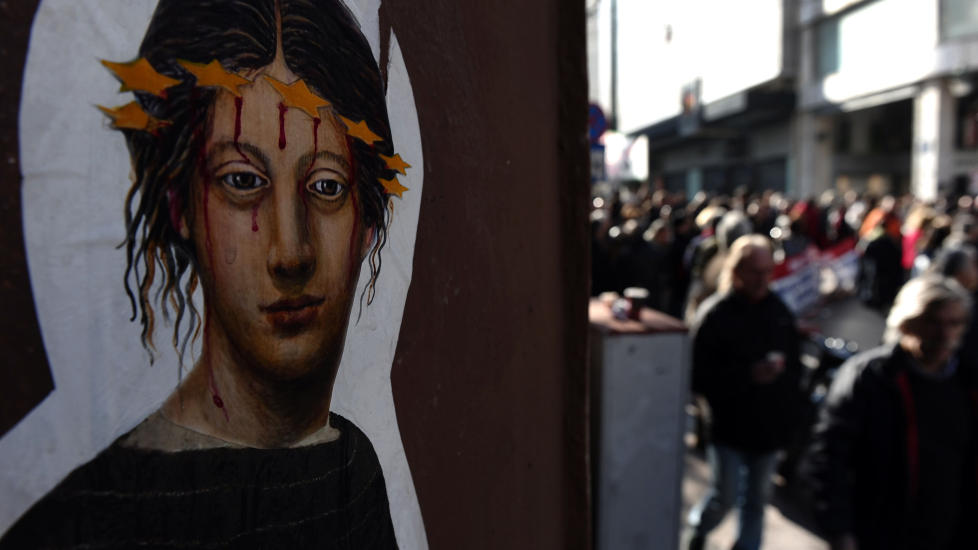 KORSFESTET: Mange grekere f�ler seg hengt p� et euro-kors av EU, som i dette veggmaleriet fra en av de mange folkelige protestene mot stadige sparetiltak. Og gamle fordommetr dukker opp p� mange kanter av EU under krisa, mot tyskere og mot grekere. WFOTO: AFP / ARIS MESSINIS