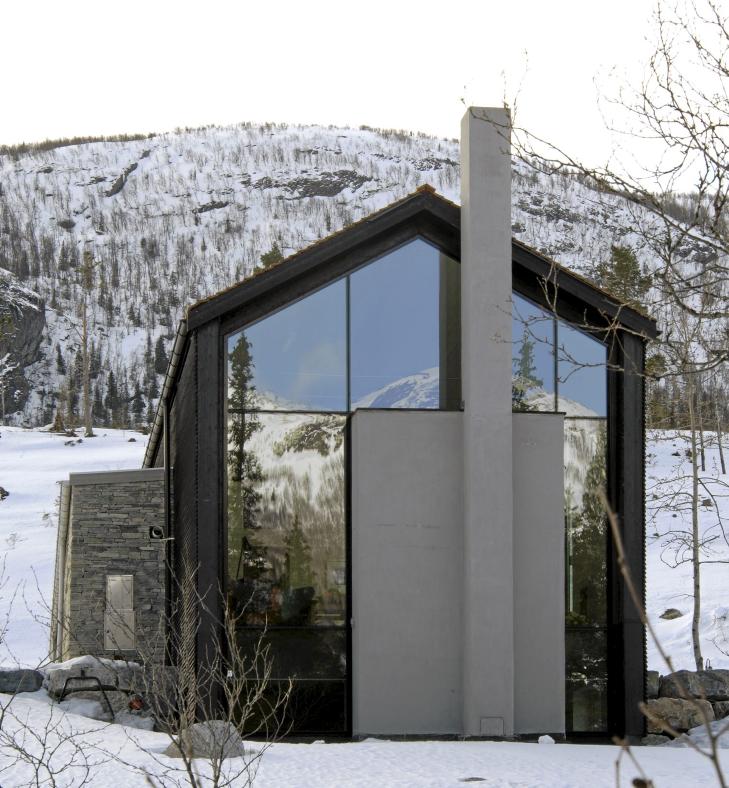 HELST�PT ARKITEKTUR: Utenfra ser man tydelig hvordan peisblokken er plassert midt i den h�ye glassfasaden. � Foto: Nils Petter Dale