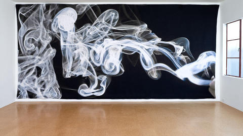 INGEN R�YK UTEN TVIL: Den amerikanske kunstneren Pae Whites tekstilverk �Smoke Knows� viser r�ykringer i et tilsynelatende tredimensjonalt spill. Men det gigantiske teppet i bomull og polyester er fullstendig flatt. Foto: Fredrik Nilsen