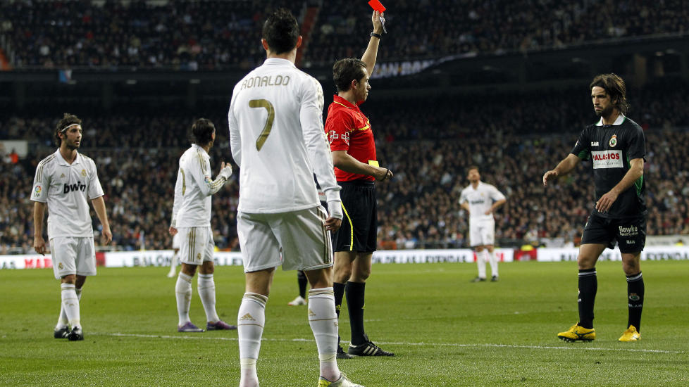 FAVORISERES? Racing Santanders Domingo Cisma (t.h) dro fram geipen da dommeren viste det r�de kortet i Madrid, foran Christiano Ronaldo. Foto: AP/Andres Kudacki