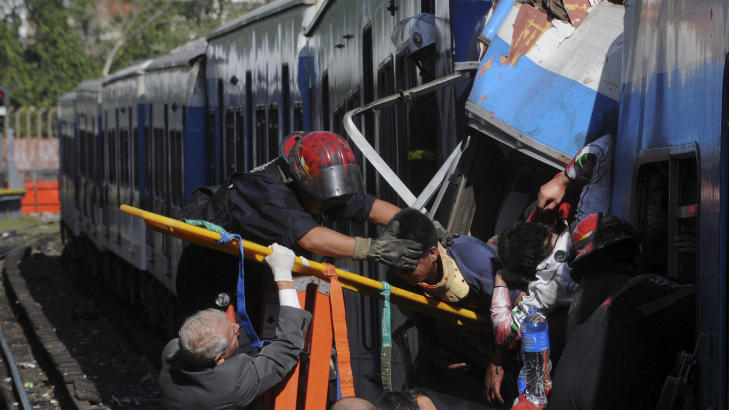 REDDES:Brannmenn redder skadde passasjerer ut av toget. Foto: Leonardo Zavattaro/AP/Scanpix