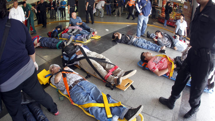 B�RER: Passasjerer ligger p� b�rer etter � ha blitt skadet i togulykken. Foto: Enrique Marcarian/Reuters/Scanpix