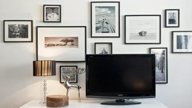 BLANT MANGE BILDER: Tv-en er her plassert blant mange bilder. Slik blir den en del av miksen p� veggen. � FOTO: Sveinung Br�then
