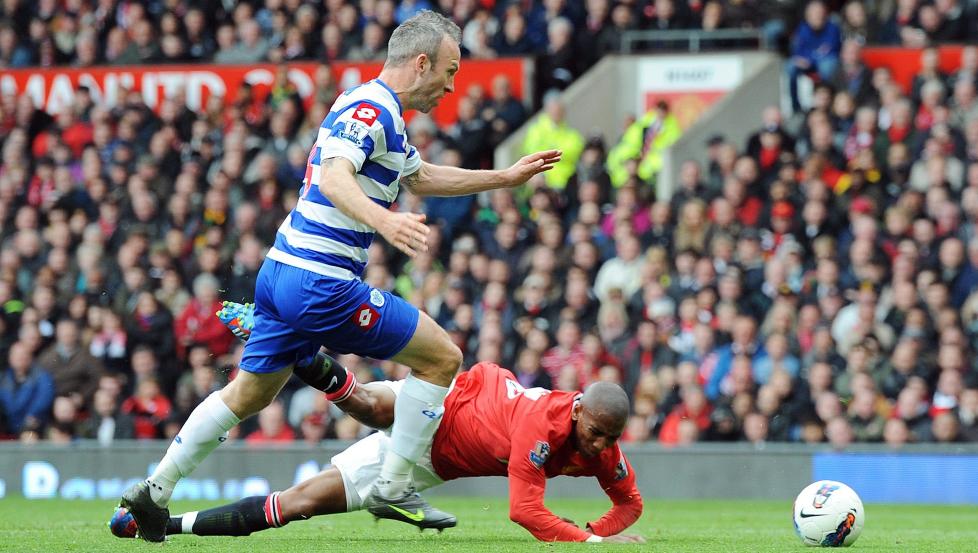 FINN FLERE FEIL: Ashley Young falt nok i overkant lett i duellen med Shaun Derry, men verre var det at han var helt tydelig offside i situasjonen. Derry og QPR ble straffet knallhardt - r�dt kort, straffe og 0-1.Foto: SCANPIX/EPA/PETER POWELL