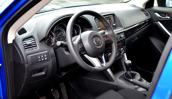 ENKELT: I likhet med i de fleste Mazdaer er interi�ret velfungerende og noks� sportslig, mer enn luksuri�st og forseggjort. De oransje lysene i midtkonsollen sender tankene tilbake til nittitallet, s� der kunne Mazdas designere godt funnet p� noe annet. Foto: ANDREAS HANDELAND