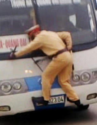 Her klamrer politimannen seg til flyktende buss