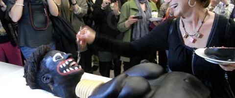 Kulturminister skar opp kake som forestilte en svart kvinne