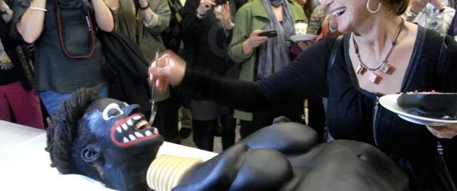 Kulturminister skar opp kake som forestilte en svart kvinne