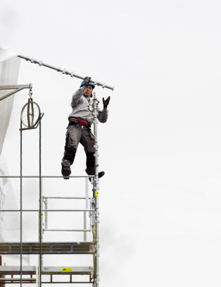 Her balanserer arbeideren usikret 15 meter over bakken