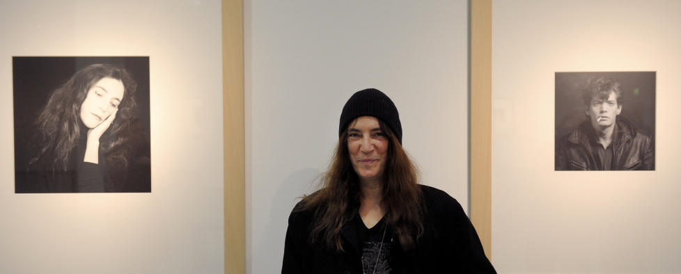PATTI OG ROBERT: Patti Smith foran Robert Mapplethorpe-portretter av de to, under en utstillings�pning i 2010. �Just Kids� er boka om deres kj�rlighets- og kunstnerliv sammen. Foto: SCANPIX