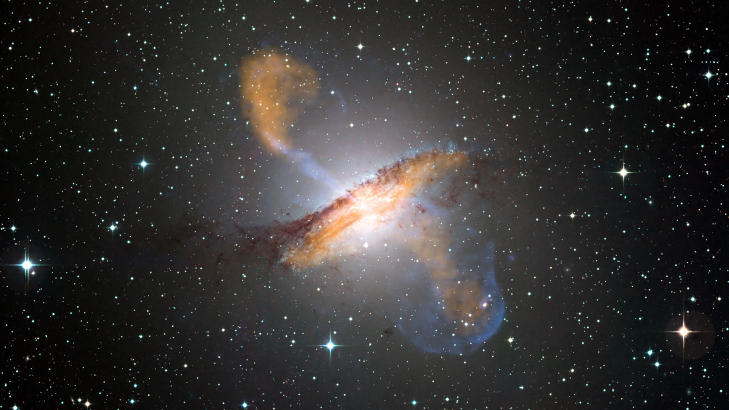 SUSER UT: De enorme jet-ene som står ut på hver side av galaksen er ikke særlig synlig i «vanlig» lys, men vises tydelig i dette fotografiet som består av bilder tatt i flere deler av spektrumet (røntgen- og mikrobølgestråling samt synlig lys). Foto: ESO/WFI/ MPIfR/ESO/APEX/A.Weiss et al/NASA/CXC/CfA/R.Kraft et al. SUSER UT: De enorme jet-ene som står ut på hver side av galaksen er ikke særlig synlig i «vanlig» lys, men vises tydelig i dette fotografiet som består av bilder tatt i flere deler av spektrumet (røntgen- og mikrobølgestråling samt synlig lys). Foto: ESO/WFI/ MPIfR/ESO/APEX/A.Weiss et al/NASA/CXC/CfA/R.Kraft et al.