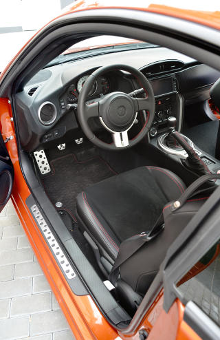 GTI-AKTIG: Dashbordet, rattet og midtkonsollen lukter mer GTI-bil enn sportsbil, men hvilken rolle spiller det? Det ser t�ft ut og fungerer godt. Legg merke til vippebryterne under klimaanlegget og de r�de s�mmene i skinn- og alcantasetene og rattet. Foto: ANDREAS HANDELAND