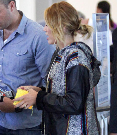  UT P� TUR:  Det er ikke vanskelig � spotte den store diamantringen p� Mileys finger. Foto: Stella Pictures