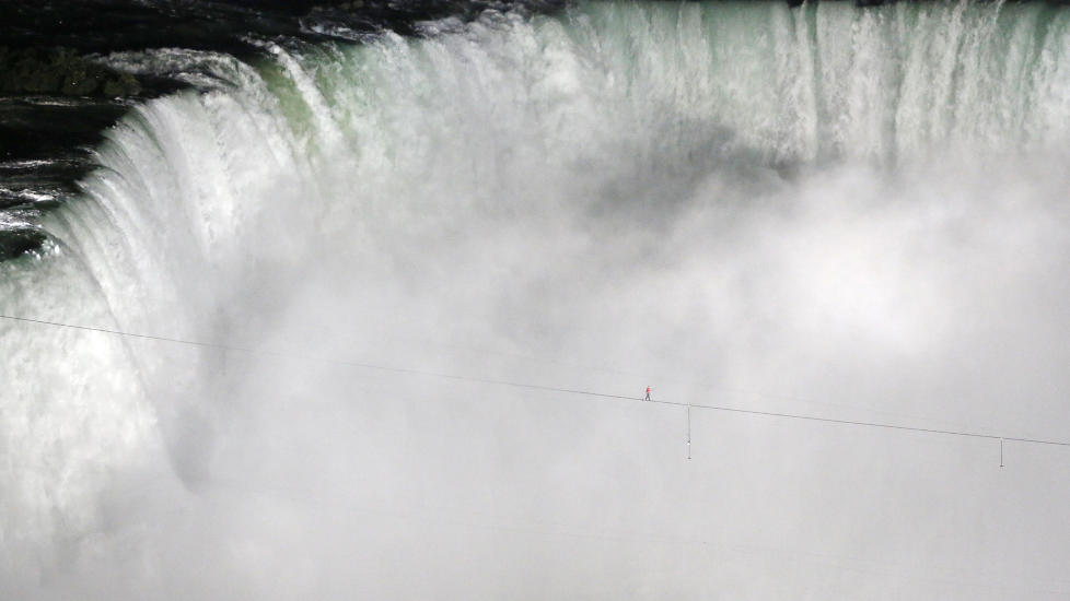 BALANSERER OVER NIAGARAFOSSEN: Amerikanske Nik Wallenda balanserte p� stram line over den ber�mte Niagarafossen p� grensen mellom USA og Canada. Turen over var p� 550 meter og tok mindre enn 30 minutter � utf�re. Foto: MARK BLINCH / REUTERS / NTB SCANPIX