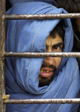 I DOSTUMS FENGSEL: En tilfangetatt talibansoldat ser igjennom gitteret i et fengsel i Shiberghan i Jawzjan-provinsen. Etter stort internasjonalt press ble en del av fangene satt fri i 2003. Foto: AP / Sergei Grits / NTB Scanpix I DOSTUMS FENGSEL: En tilfangetatt talibansoldat ser igjennom gitteret i et fengsel i Shiberghan i Jawzjan-provinsen. Etter stort internasjonalt press ble en del av fangene satt fri i 2003. Foto: AP / Sergei Grits / NTB Scanpix