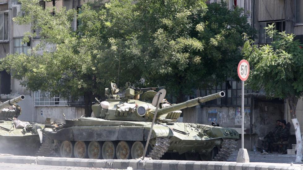 � RENSKE: P� dette viset sl�ss regimet til president Bashar al-Assad mot sine egne innbyggere. Her ruller stridsvogner inn i bydelen al-Midan i Damaskus, som regjeringsstyrkene har gjenerobret fra oppr�rerne. Statlig fjernsyn sier myndighetene har �rensket� bydelen for �terrorister�. Foto: AFP / LOUAI BESHARA
