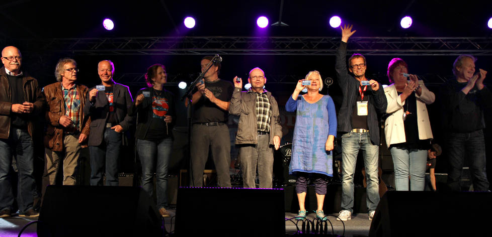 HEDRET GR�NDERNE: De 14 som startet Notodden Blues Festival for 25 �r siden, her ved ti av dem, ble hyllet i kveld med hvert sitt Bl�kort - som gir dem gratis inngang p� festivalen s� lenge de lever. Foto: Bj�rn-Owe Holmberg / Dagbladet