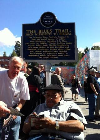 BLUESHEDER: Munnspiller James Cotton foran skiltet Notodden har f�tt fra staten Mississippi - som den f�rste byen utenfor USA. Den er et bevis p� at Notodden er en ekte bluesby. Finn Koldrup, som arrangerer turer til Mississippi, sikret seg autografen. Foto: �yvind R�nning / Dagbladet