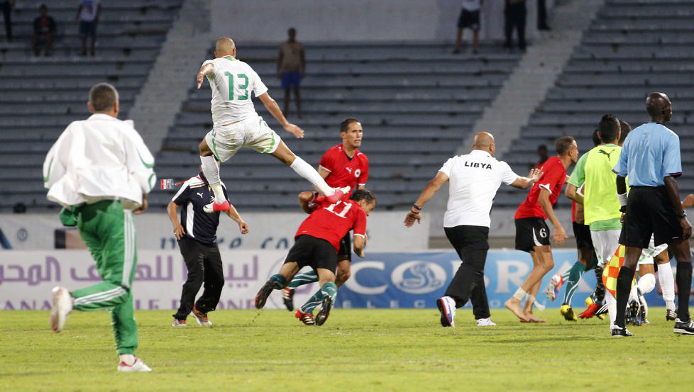 STYGT ANGREP: Algeries Islam Slimani hopper opp og sparker Libyas Mohamed El Mughrabi etter kvalifiseringskampen til afrikamesterskapet p� s�ndag. Foto: MACAO / REUTERS / NTB SCANPIX