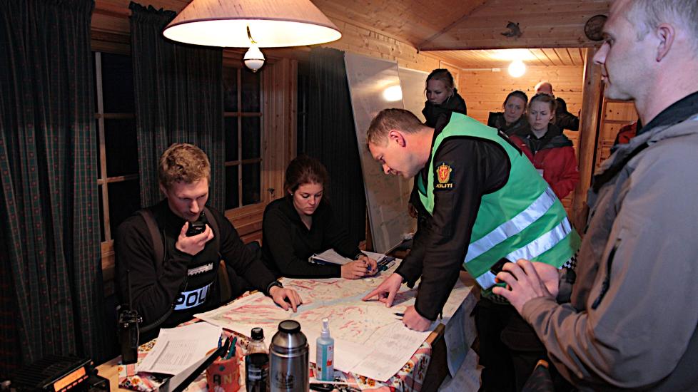 Politiet har opprettet en base ved demningen ved Altevatn hvor de organiserer letearbeidet fra. P� bildet er politiets innsatsleder p� stedet Jon K�re Granheim fra M�lselv lennsmannskontor og frivillige som deltar i leteaksjonen. Foto: Stein Wilhelmsen / Nordlys