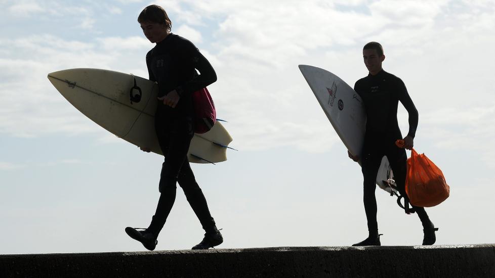 <b>BØLGEDYRKERE</b> Surferne Dean Walter (t.v.) og Henry Young (t.h.) benyttet dagen etter stormens herjinger til å teste bølgene utenfor Scituate i Massachusetts.