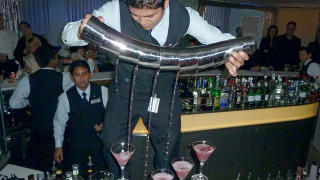 BARKUNST: Ogs� i baren p� verdens nyeste cruiseskip kan du oppleve h�ydepunkter. Denne bartenderens glansnummer er � fylle syv cocktailglass - samtidig. Foto: EIVIND PEDERSEN