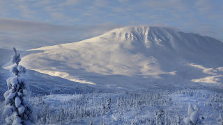DESEMBER: Gaustatoppen bader i formiddagssol, mens skyggelandskapet ligger bl�tt i 11 kuldegrader. Foto: OLE C. H. THOMASSEN
