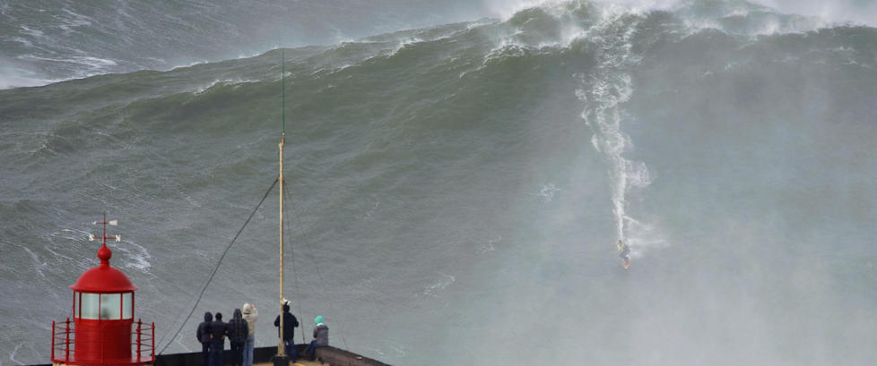 Her surfer han den 30 meter høye bølgen