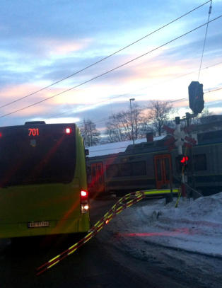 Rutebuss m�tte rygge vekk fra skinnene da toget kom - etter at bommen var g�tt ned