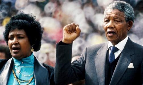 SVART MAKT: Den tidligere presidenten hilser de mange tusen som m�tte opp i Soweto for � �nske han �velkommen hjem�, etter han ble l�slatt fra fengsel i 1990. Den knyttede neven er et kjent symbol fra Black Power-bevegelsen, ud�deliggjort av Tommie Smith og John Carlos markering under OL i 1968 i Mexico by. Mandela st�r her ved siden av sin tidligere kone Winnie Mandela, som var blant de ledende, men ogs� mest kontroversielle representantene for anti-apartheid-bevegelsen.  Foto: SCANPIX/EPA/STR