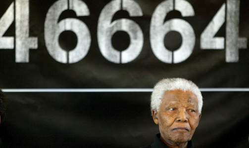 FANGENUMMER 46664: For sin politiske deltakelse i den etterhvert voldelige frihetsbevegelsen African National Congress, satt Nelson Mandela fengslet i totalt 27 �r p� Robben Island. Her bar han fangenummeret 46664, en tallkode han siden har fylt med positivt innhold. Her er han avbildet under en av de mange 46664-konsertene han arrangerer, blant annet for � skape oppmerksomhet om aidsproblematikken p� det Afrikanske kontinentet.  Foto: SCANPIX/EPA
