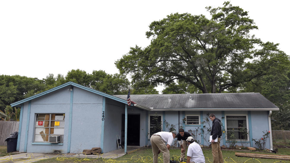 TATT AV HULL: Ingeni�rer jobber utenfor boligen til den 36 �r gamle mannen som enn� ikke er funnet etter � ha blitt slukt av et synkehull. Foto: AP / Chris O'Meara