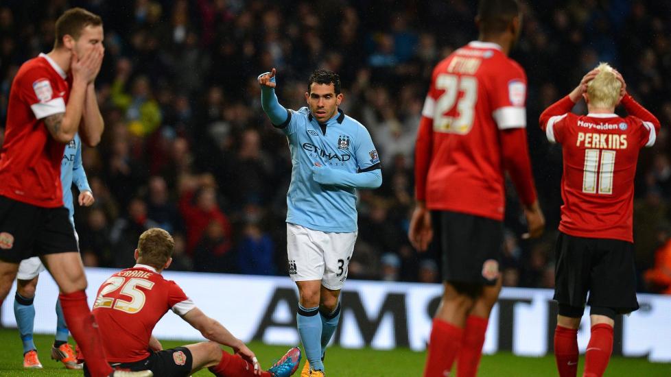SENKET BARNSLEY: Carlos Tevez scoret hattrick i dagens FA-cupm�te mellom Manchester City og Barnsley. Her feirer Tevez sitt siste m�l foran fortvilede Barnsley-spillere. Foto: AFP PHOTO/ANDREW YATES