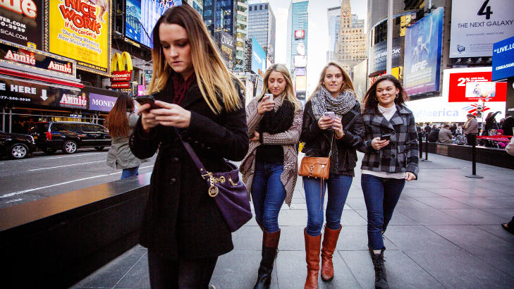 TELEFONGUIDE: Haley Gonzales, Sara Deffeize, Julia Nelson og Hanna Bumgamer er alle dypt  konsentrerte p� smarttelefonene sine der de spaserer gjennom Times Square New York. Nyttige apper til smarttelefoner gj�r at du i stor grad kan legge igjen guideboka p� hotellet. Men huske � l�fte blikket opp fra telefonen - og nyt at du er i verdensmetropolen. Foto: �RJAN F. ELLINGV�G