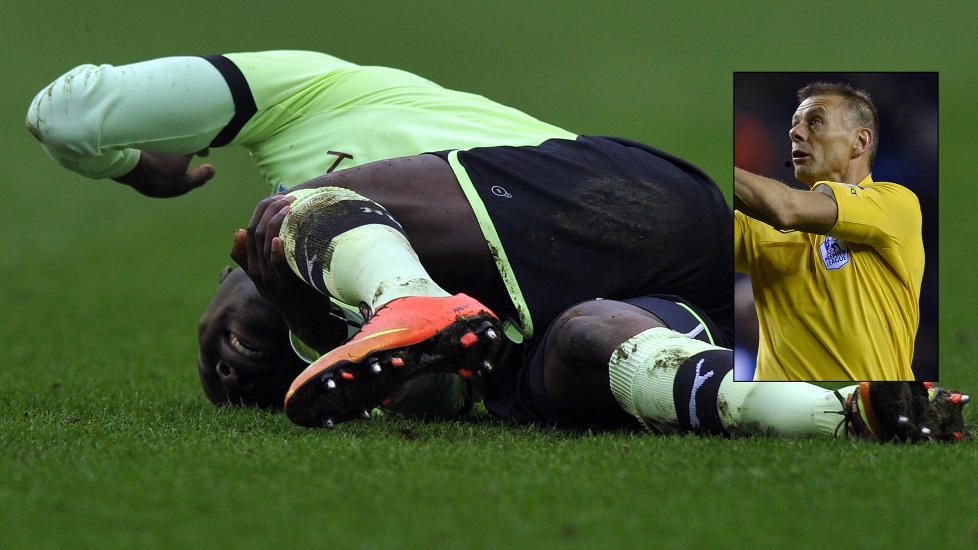 S� IKKE TAKLINGEN: Massadio Haidara vrir seg i smerte etter den stygge taklingen. Dommer Mark halsey mener han ikke s� taklingen. Foto: AFP PHOTO / PAUL ELLIS / NTB scanpix