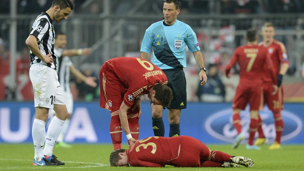 HOFTA:  Mario Mandzukic fors�ker � hjelpe Toni Kroos som ligger nede. Hofteskaden han p�dro seg under 2-0 kampen mot Juventus gj�r at han er ute av spill i to m�neder. Foto: AFP PHOTO / CHRISTOF STACHE / NTB Scanpix