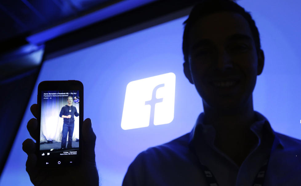 APPARATSJIK: Michael Goodwin hos mobilprodusenten HTC viser fram en HTC First-telefon med Facebooks nye Home-appfamilie installert. Foto: AP/SCANPIX