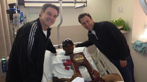 TRENERBES�K: Luisville-trenerne hadde med seg trofeet fra finalekampen da bes�kte Ware p� sykehuset. Foto: REUTERS/The University of Louisville/ NTB SCANPIX