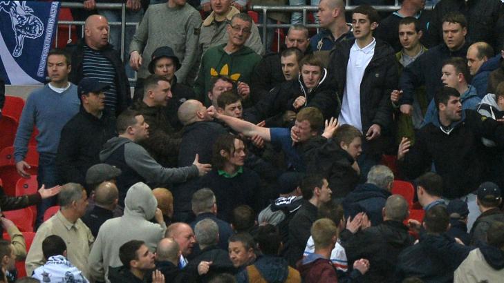 STRAK H�YRE: Her ser vi en Milwall-fan rette knyttneven rett i fleisen p� en medsupporter. Foto: AFP/PAUL ELLIS