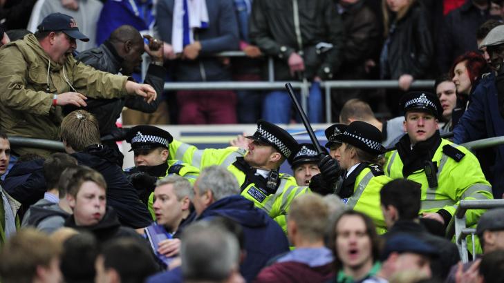 BANET SEG VEI: Politiet m�tte dra frem batongene for � bane seg frem og pr�ve � roe ned situasjonen. Foto: AFP/GLYN KIRK