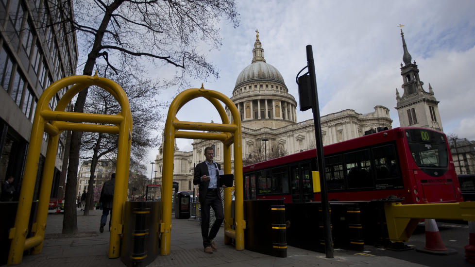 STRENG SIKKERHET: En mann passerer sikkerhetsbarrierene som er satt opp utenfor St Paul's Cathedral in London, der seremonien for avd�de Margaret Thatcher holdes i morgen. Britisk politi skjerper sikkerheten foran s�ndagens London Marathon, det neste store internasjonale maratonl�pet. Foto: AP Photo/Matt Dunham.