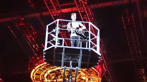 Bieber synger og spiller gitar fra en kran over publikum.