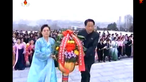 Patriotisme i blomsterkurv: Disse to unders�ttene uttrykker sin �refrykt for diktatorstatuene gjennom en bugnende blomsteroppsats. Barna f�r ikke nok � spise og befolkningen tuktes, men de m� forst� at alle tilgjengelige ressurser m� g� til milit�r opprustning.